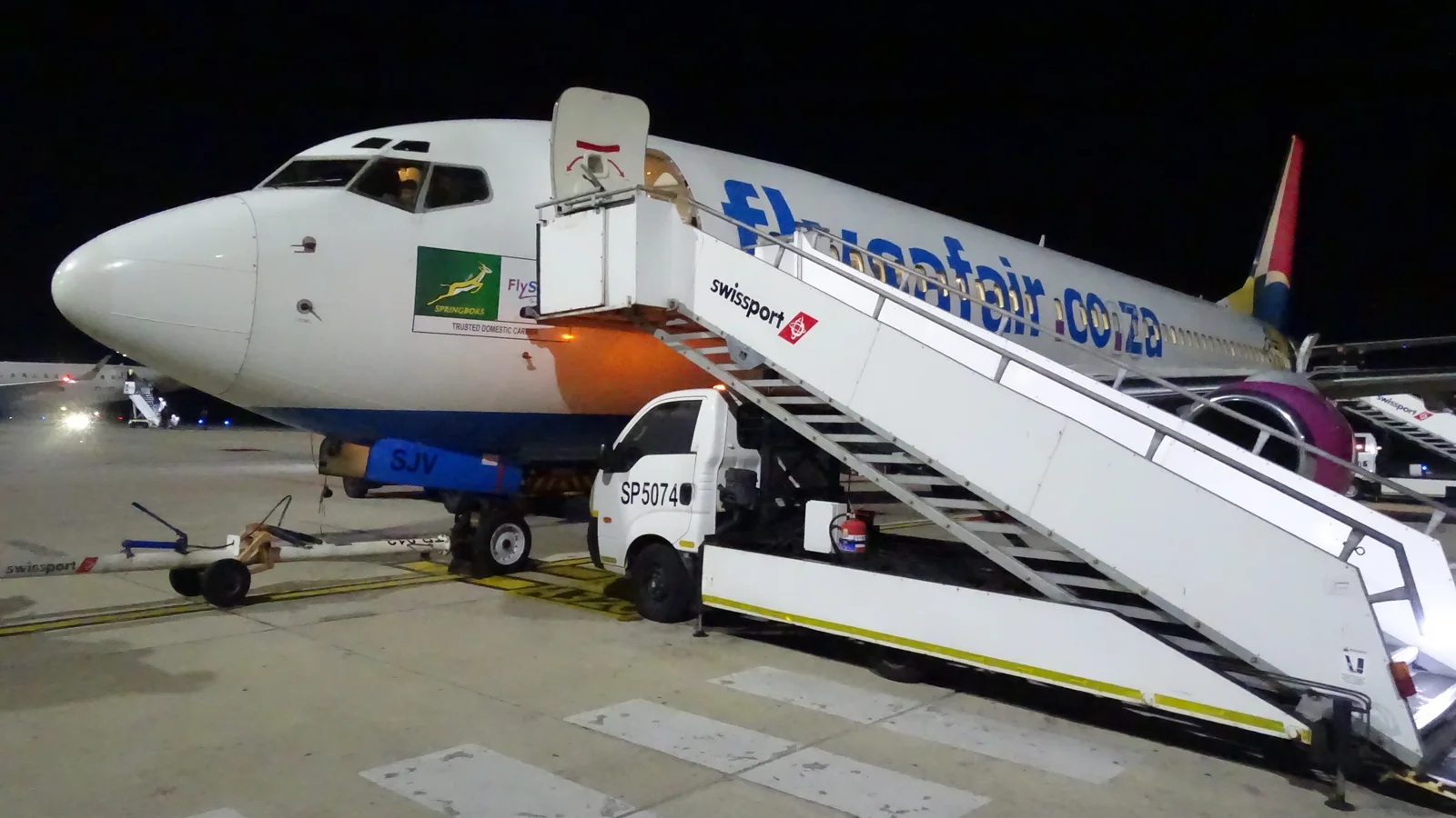 FlySafair Boeing 737 at the gate with boarding stairs